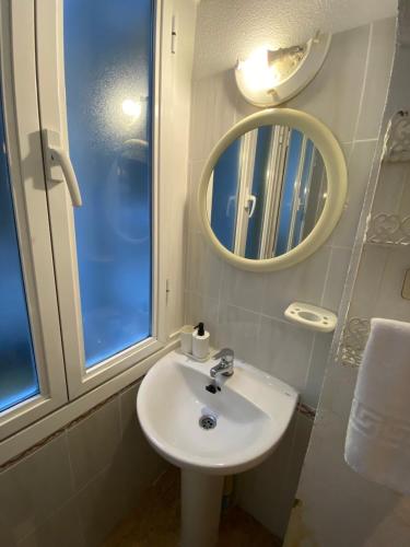a bathroom with a white sink and a mirror at Center Madrid habitaciones in Madrid