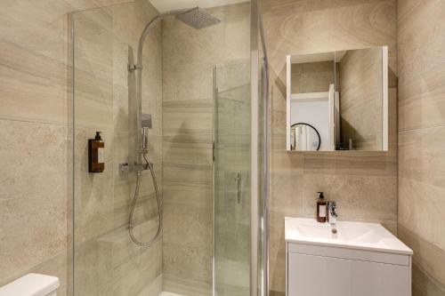 a bathroom with a shower and a sink at Hounslow Apartments by Charles Hope in Hounslow
