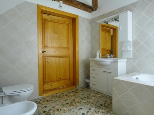 a bathroom with a toilet sink and a wooden door at Lindenhof in Murau