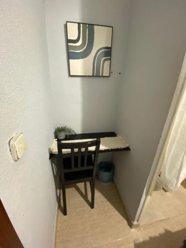 a small table and a chair in a room at Center Madrid habitaciones in Madrid