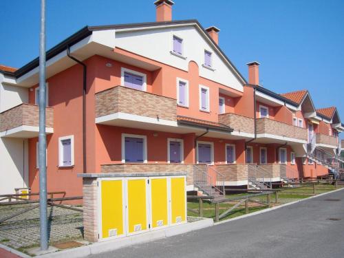 un bâtiment orange et blanc avec des portes jaunes dans une rue dans l'établissement Apartment Solmare-8 by Interhome, à Rosapineta