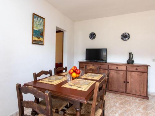 een eetkamer met een tafel en een televisie bij Apartment S'Olivera-6 by Interhome in Begur