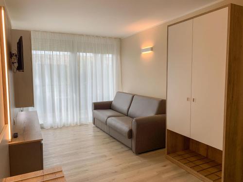 sala de estar con sofá y ventana grande en Apartment Parco del Garda-4 by Interhome, en Garda