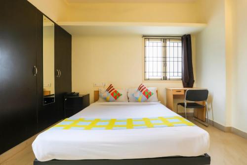 sypialnia z dużym łóżkiem i biurkiem w obiekcie OYO Home Harma Residency Near Koyambedu Metro Station w mieście Ćennaj