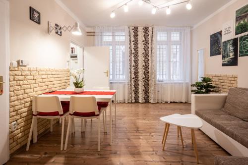 Una sala de estar con una mesa y sillas y un sofá. en Zensen Nest Apartment, en Budapest