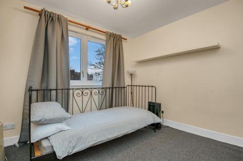 1 dormitorio con cama y ventana en Edinburgh City Center Coady Apartment SLEEPS 5 FREE CAR PARK SPACE, en Edimburgo