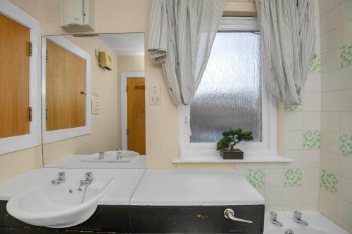 Baño con 2 lavabos y espejo en Edinburgh City Center Coady Apartment SLEEPS 5 FREE CAR PARK SPACE, en Edimburgo