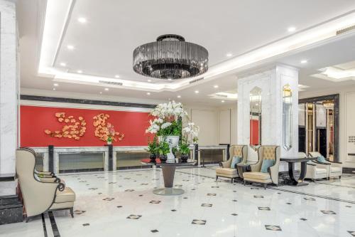 a lobby with chairs and a table and a red wall at Meliá Vinpearl Nha Trang Empire in Nha Trang