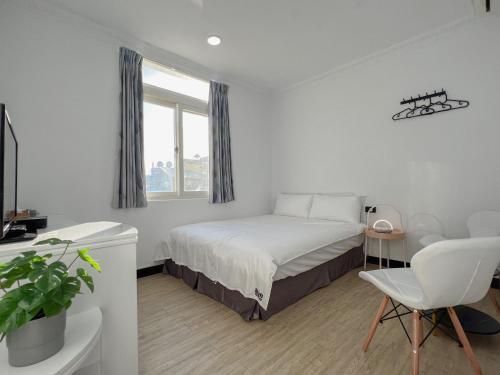 1 dormitorio con cama, escritorio y silla en Party& Dream Homestay, en Kenting