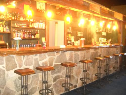 eine Bar mit einer Reihe von Hockern in einem Zimmer in der Unterkunft Apartmány Areál Ados in Harrachov