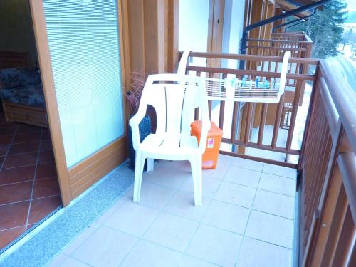 a pair of white chairs sitting on a balcony at Appartamento finestra sul parco in Comano Terme