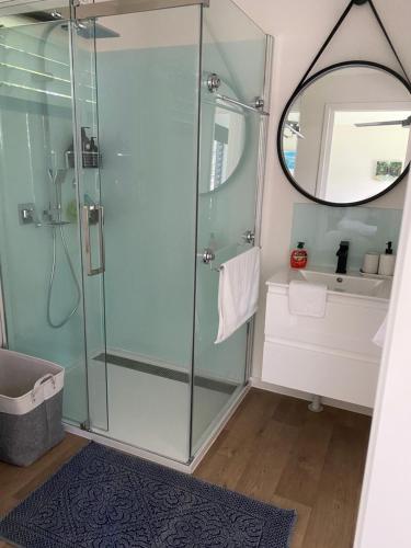 a bathroom with a shower and a mirror at Haven Guesthouse in Holloways Beach