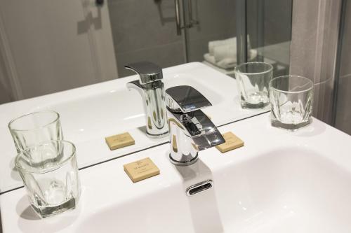 un lavandino con due bicchieri e un rubinetto in bagno di Castle Varagh Hotel & Bar a Contea di Westmeath