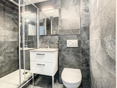a bathroom with a toilet and a sink and a shower at Apartment Les Burons-3 by Interhome in Les Menuires
