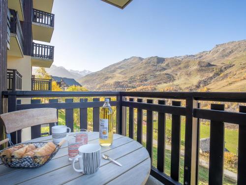 - une table avec une bouteille de vin et du pain sur le balcon dans l'établissement Apartment Balcons d'Olympie 203 - A by Interhome, aux Menuires