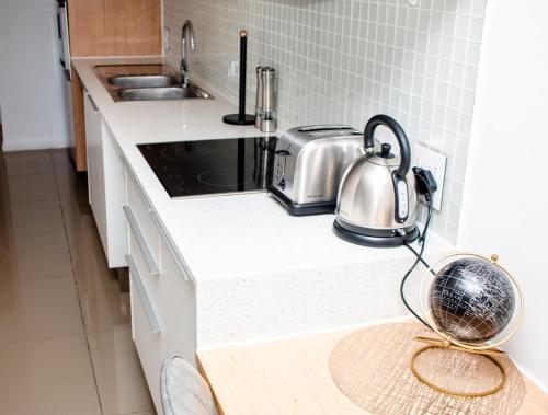 a kitchen counter with a tea kettle on the counter at Urban Oasis Apartments at Freedom Plaza in Windhoek