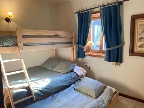 a bedroom with two bunk beds and a ladder at Baqueira Pleta de Neu in Naut Aran