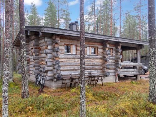 una cabaña de madera en el bosque con mesa y sillas en Holiday Home Hakojärven kelomajat 2 by Interhome, en Ruka