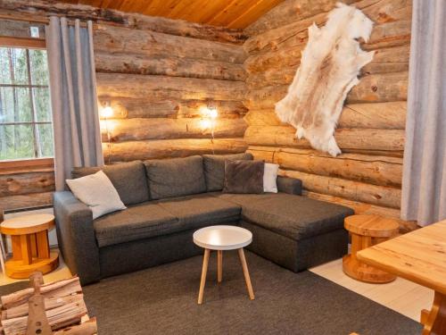 ein Wohnzimmer mit einem Sofa in einem Blockhaus in der Unterkunft Holiday Home Hakojärven kelomajat 2 by Interhome in Ruka