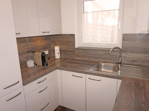 a kitchen with white cabinets and a sink at Apartment FeWo Anna by Interhome in Fliess