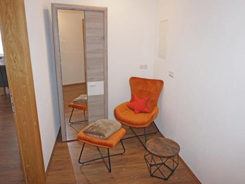 an orange chair and a stool in a room at Apartment FeWo Anna by Interhome in Fliess