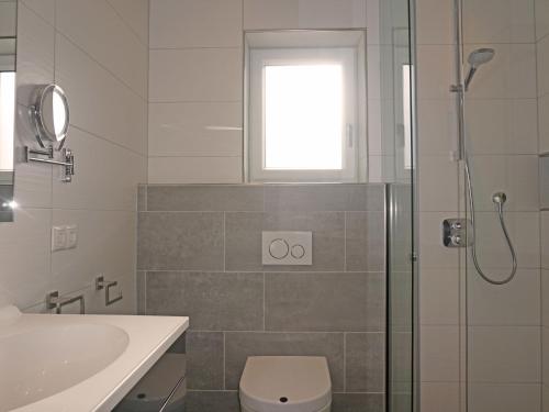 a bathroom with a shower and a toilet and a sink at Apartment FeWo Anna by Interhome in Fliess