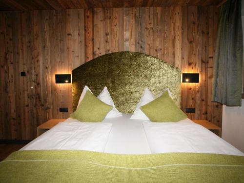 a bedroom with a large white bed with green pillows at Apartment Erzherzog's Apts-Zillertal Kaiser Lodge by Interhome in Uderns