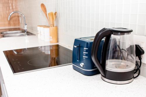 a blue and black appliance sitting on a kitchen counter at Urban Oasis Apartments at Freedom Plaza in Windhoek