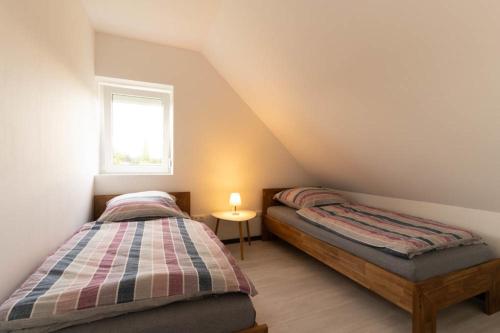 2 camas individuales en un dormitorio ático con ventana en Ferienwohnung 140 qm OstfrieslandNordsee für 1-6 Personen - Südbrookmerland en Südbrookmerland