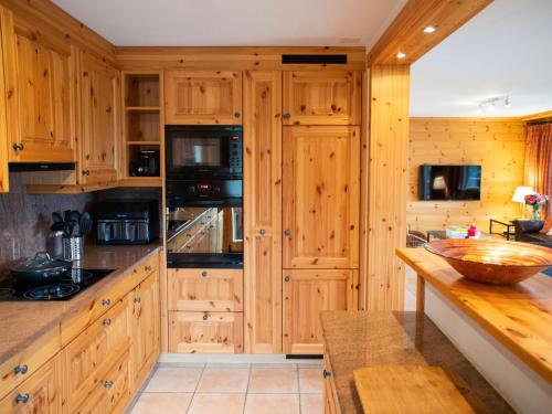 une cuisine avec des armoires en bois et un comptoir dans l'établissement Apartment Ambre 1 by Interhome, à Villars-sur-Ollon