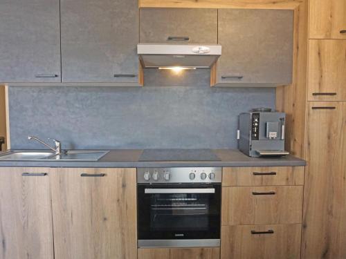 a kitchen with a stove and a sink and a microwave at Apartment Apart Handle by Interhome in Alterzoll
