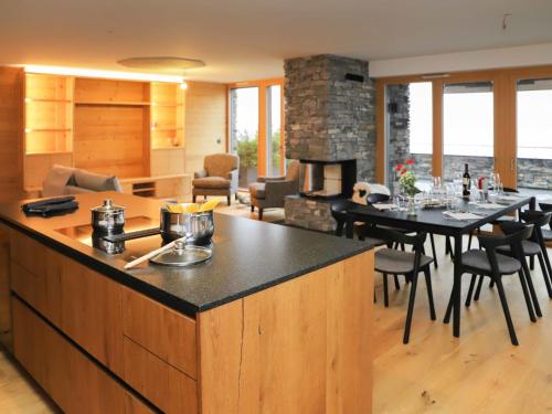 uma cozinha e sala de estar com uma mesa e uma lareira em Apartment Hédonia A7 by Interhome em Villars-sur-Ollon