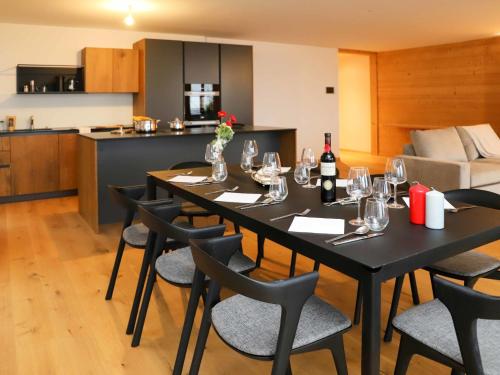uma sala de jantar com uma mesa e cadeiras com copos de vinho em Apartment Hédonia A7 by Interhome em Villars-sur-Ollon