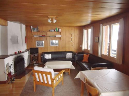 uma sala de estar com um sofá e uma mesa em Chalet Chalet Pitschun by Interhome em Grindelwald