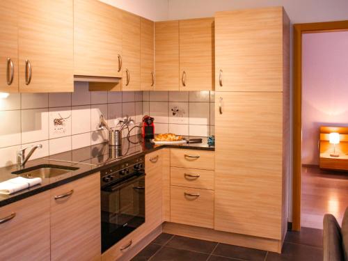 una cocina con armarios de madera y fregadero en Apartment Andromède 6 by Interhome, en Moleson
