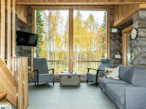 a living room with a couch and chairs and a tv at Holiday Home Kojamopirtit by Interhome in Kolari