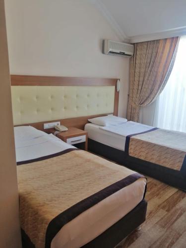 a hotel room with two beds and a window at MiTOS APART OTEL in Alanya