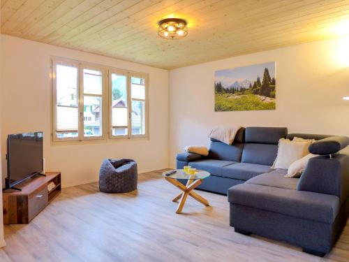 a living room with a couch and a tv at Holiday Home Chalet Dori by Interhome in Interlaken