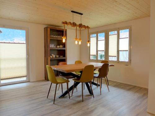 ein Esszimmer mit einem Holztisch und Stühlen in der Unterkunft Holiday Home Chalet Dori by Interhome in Interlaken