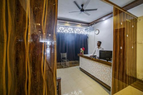 un hombre parado en un mostrador en una habitación de hotel en OYO Hotel Vip, en Kota