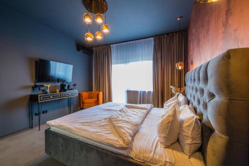a bedroom with a large bed and a television at Pensiunea Casa Buna in Gîrbova