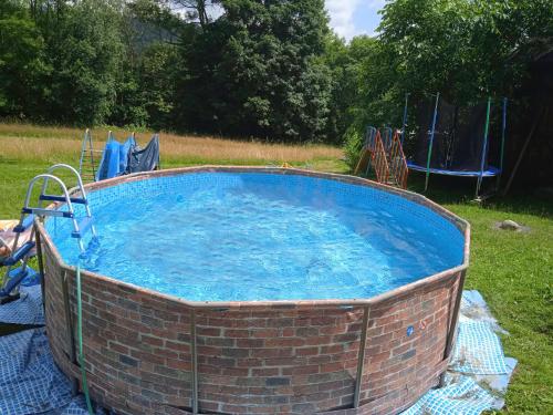 uma grande piscina de tijolos com água azul num quintal em Holiday Home Zlatá Olešnice 122 by Interhome em Zlatá Olešnice