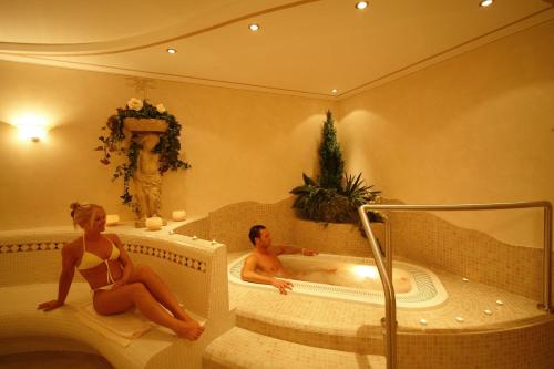 a man and woman sitting in a tub in a bathroom at Appartements Steiner in Valdaora