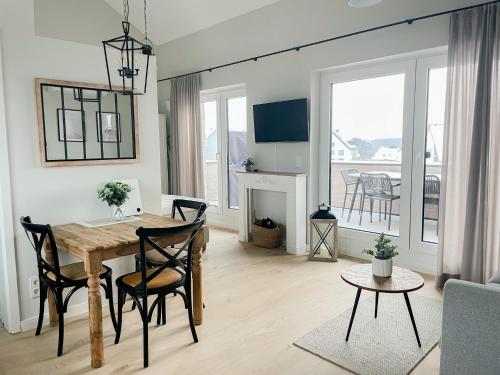 ein Wohnzimmer mit einem Tisch und Stühlen sowie ein Esszimmer in der Unterkunft Ferienwohnung Baltic Idyll in Scharbeutz
