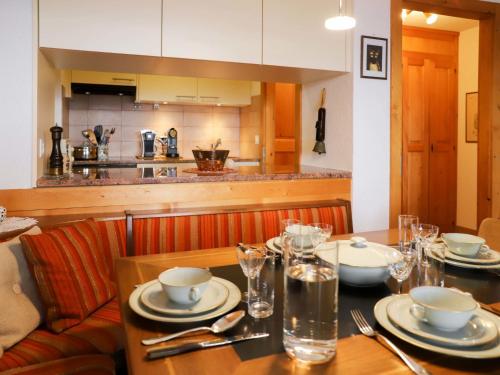 a dining room table with plates and glasses on it at Apartment Grand Hôtel B47 by Interhome in Villars-sur-Ollon