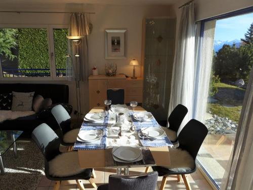 una sala da pranzo con tavolo, sedie e finestra di Holiday Home Maison N-35 by Interhome a Bluche