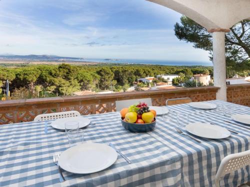 una mesa con platos y un bol de fruta en el balcón en Holiday Home Can Delmas by Interhome, en Pals