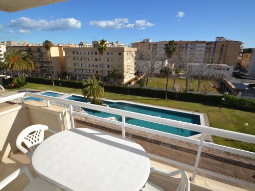 balcón con mesa y sillas y piscina en Apartment Aguamarina-4 by Interhome en La Pineda