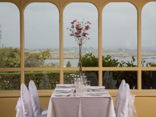 a table with white chairs and a vase with flowers at Casey's Of Baltimore Collection in Baltimore