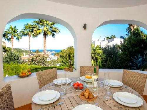 - une salle à manger avec une table, des chaises et des palmiers dans l'établissement Villa Villa Scott by Interhome, à Jávea